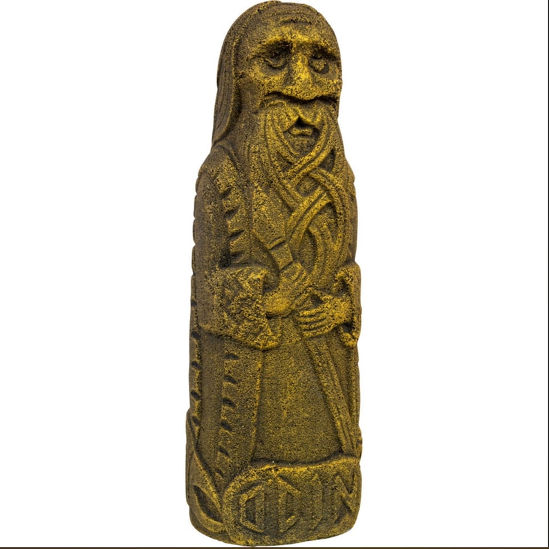 Puede incluir: Una escultura de piedra de color dorado que representa a un hombre barbudo con tallas intrincadas. La escultura es alta y delgada, con una cara detallada y una larga barba. El hombre lleva una t&uacute;nica larga y sostiene un bast&oacute;n en su mano.