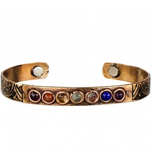 May include: A copper magnetic bracelet with seven colorful gemstones. The bracelet has a decorative design on the sides and a magnetic clasp.