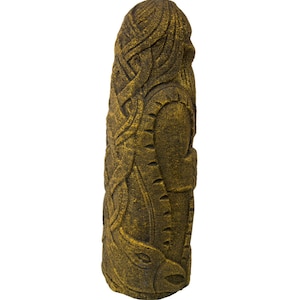 Puede incluir: Una estatua de piedra tallada, de color dorado, que representa a una persona con el pelo largo y barba. La estatua est&aacute; de pie y tiene una superficie texturizada.