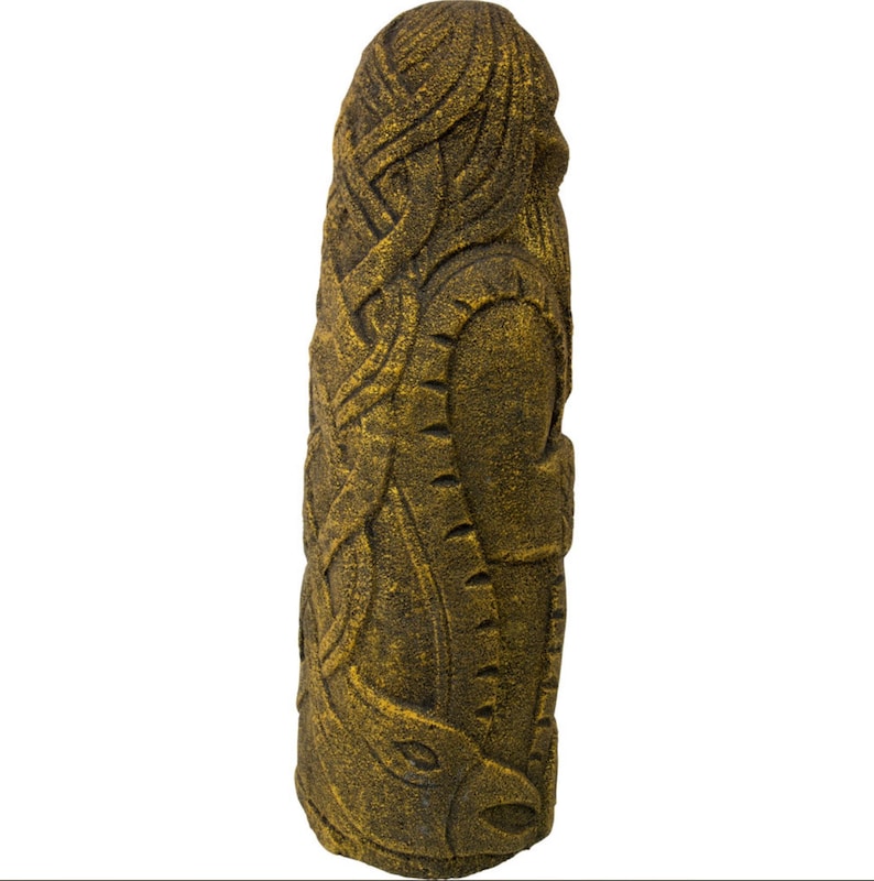 Puede incluir: Una estatua de piedra tallada, de color dorado, que representa a una persona con el pelo largo y barba. La estatua est&aacute; de pie y tiene una superficie texturizada.