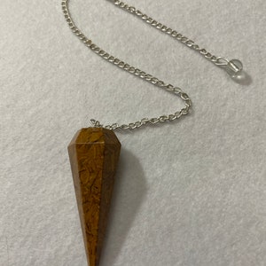 This beautiful Yellow Jasper Pendulum is 1.75” with the chain it is approximately 10.5”.