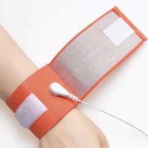 May include: Orange fabric wristband with a white sensor and a white wire attached. The wristband has a white velcro closure.