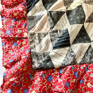 May include: A red and white patchwork quilt with a floral border. The quilt is made of various fabrics, including cotton and linen. The quilt is in good condition and would make a great addition to any home.