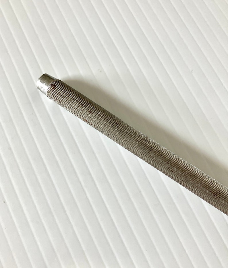 May include: A silver metal file with a ridged surface. The file is used for sharpening tools.