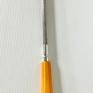 May include: A silver metal file with a yellow plastic handle. The handle has a geometric design.