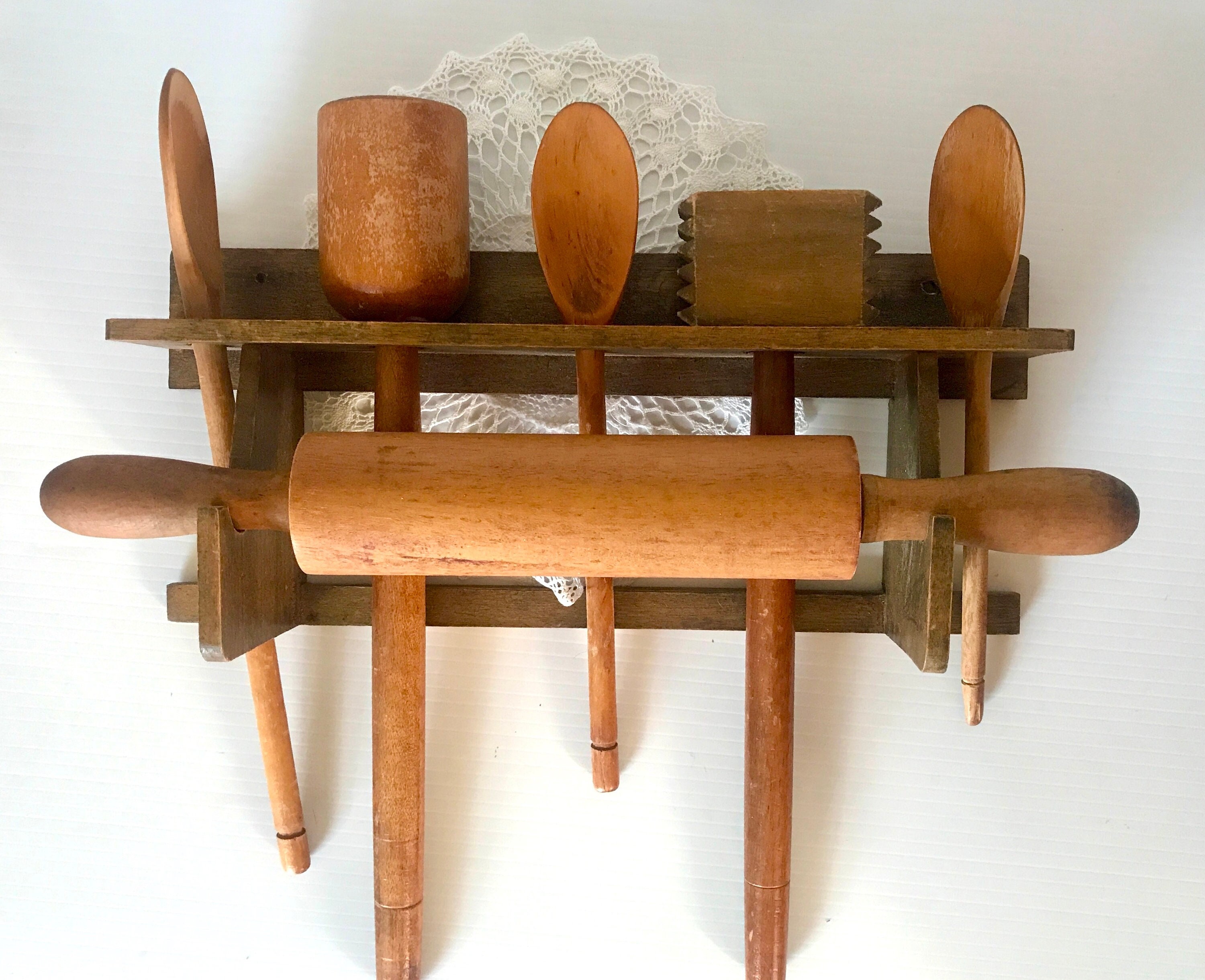 A collection of vintage wooden cooking utensils, spoons, rolling pin