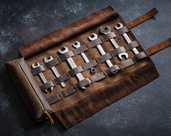 May include: A brown leather roll-up tool holder with a zipped pouch. The roll-up has multiple slots for holding spanners. The roll-up is unrolled and the slots are filled with spanners.