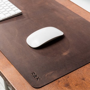 May include: A brown leather desk mat with a white mouse and the text "R&K" embossed on the bottom right corner.