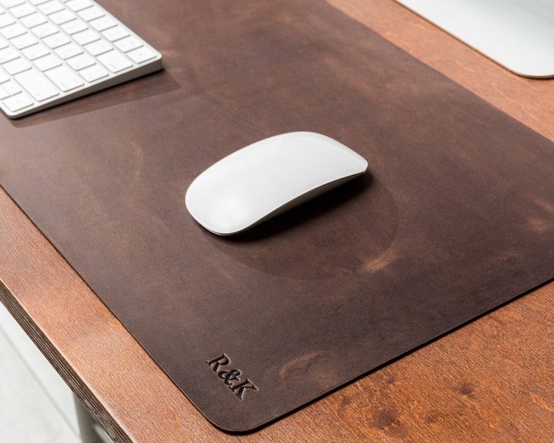 May include: A brown leather desk mat with a white mouse and the text "R&K" embossed on the bottom right corner.
