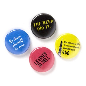 May include: Four round buttons with different sayings. The first button is blue with white text that says "To thine oboeself be true." The second button is black with yellow text that says "The Reed Did It." The third button is pink with black text that says "Licensed To Trill." The fourth button is yellow with black text that says "The answer to life, the universe and everything is 440."