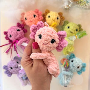 May include: A set of three ceramic mugs with a speckled, matte finish. The mugs are in shades of cream, light gray, and dark gray. Each mug has a simple, minimalist design and a rounded handle.