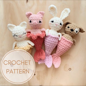 Puede incluir: Cuatro peluches de cola de sirena de crochet en diferentes colores y diseños de animales: un cerdo rosa, un conejito blanco, un perro marrón y un gato blanco. Todos los peluches llevan colas de sirena de crochet.