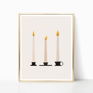 May include: Three white candles with black candle holders and yellow flames are arranged in a row on a beige background. The candles are in a gold frame.