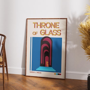 Może przedstawiać: Oprawiony plakat z napisem "THRONE OF GLASS" złotymi literami. Plakat przedstawia niebieskie tło z serią łukowatych drzwi w odcieniach czerwieni i czerni. Nazwisko autora, Sarah J. Maas, znajduje się na dole.