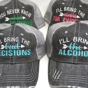 May include: Four gray and white trucker hats with different embroidered sayings. The hats have a mesh back and a black brim. The sayings on the hats are "You never know what I'm bringing", "I'll bring the camera for evidence", "I'll bring the bad decisions", and "I'll bring the alcohol".