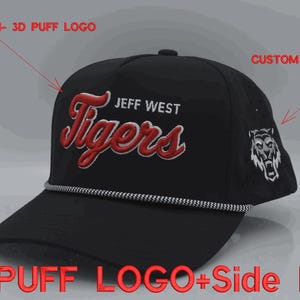 May include: A black baseball cap featuring a red and white 3D puff embroidered logo that reads JEFF WEST Tigers on the front, a white and black braided rope across the brim, and a white flat embroidered tiger head logo on the side panel.