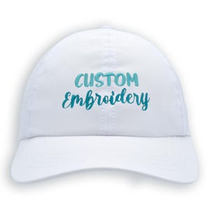 May include: White baseball cap with the text "CUSTOM Embroidery" in blue and teal embroidery.