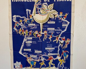 May include: A vintage blue and white tea towel with a map of France showing the different wine regions. The map is surrounded by a border of grapes and vines. The text "Vignobles de France" is printed at the top of the towel.