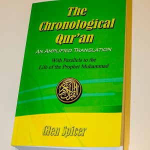 May include: A green and yellow book titled "The Chronological Qur'an: An Amplified Translation with Parallels to the Life of the Prophet Muhammad" by Glen Spicer.
