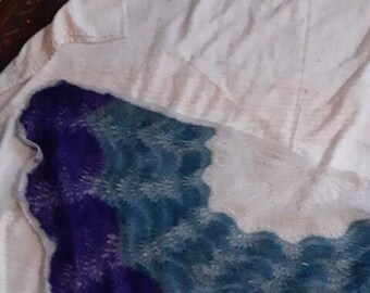 May include: A crocheted shawl with a scalloped edge in shades of purple, teal, and white.