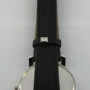May include: A silver and black wristwatch with a round face and a black leather band.