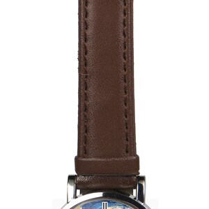 May include: A brown leather wristwatch with a silver case and a white face. The face of the watch features a reproduction of Vincent van Gogh's "The Starry Night" painting.