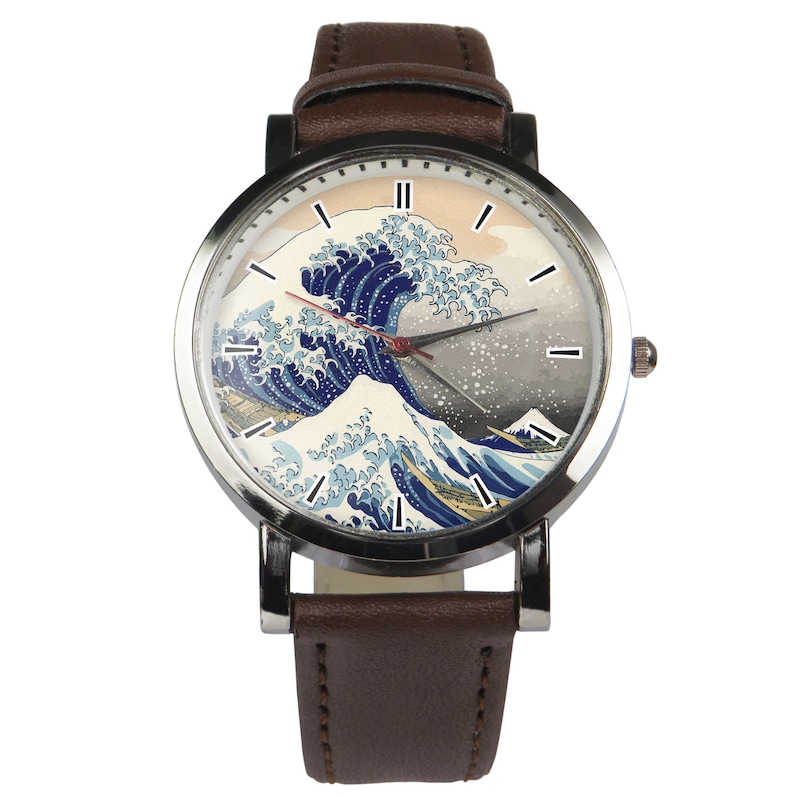 May include: A brown leather wristwatch with a silver case and a white face featuring a print of "The Great Wave off Kanagawa" by Hokusai. The watch has black Roman numeral hour markers and a red second hand.