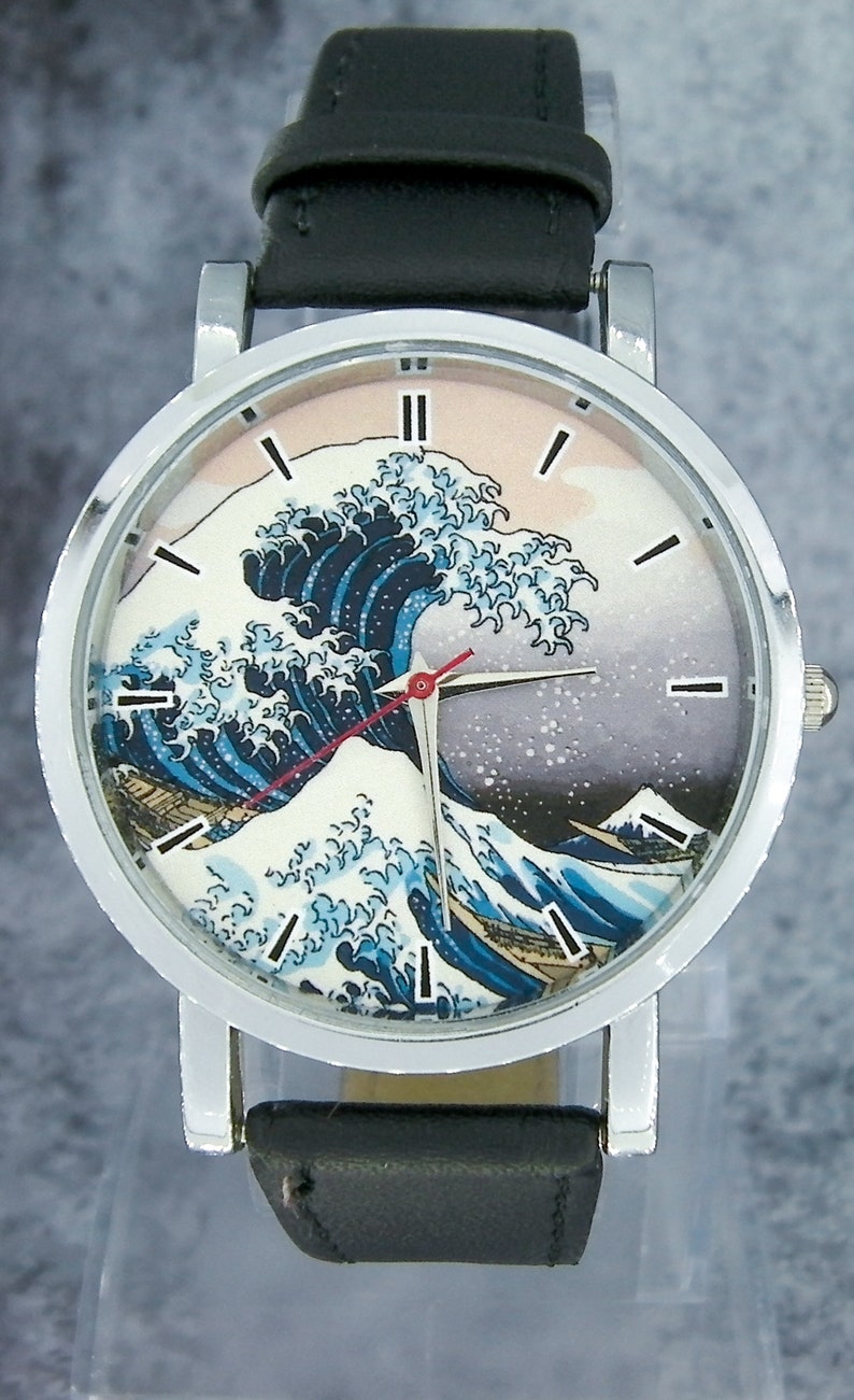 May include: A silver wristwatch with a black leather band features a colorful print of "The Great Wave off Kanagawa" by Katsushika Hokusai on the face.