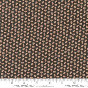 May include: A black fabric with a repeating pattern of small orange pumpkins. The fabric is shown with a ruler measuring 7 inches.