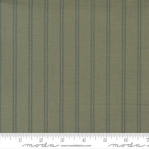May include: Green and white striped fabric with a subtle texture. The fabric is shown with a ruler for scale, with the text "moda" printed on the ruler.