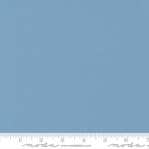 May include: A solid blue fabric swatch with a subtle texture. The fabric is measured in inches with the text "moda" printed on the ruler.