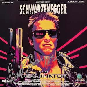 May include: Laserdisc cover for "The Terminator" featuring Arnold Schwarzenegger. The image has a vibrant color scheme with a portrait of Schwarzenegger wearing sunglasses and holding a gun. The title and actor's name are prominently displayed.
