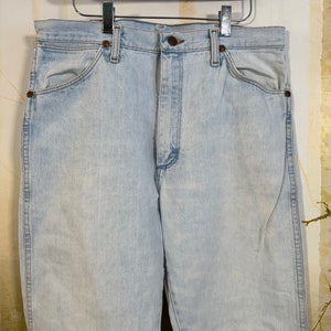May include: Light blue denim jeans with a classic five-pocket style. The jeans have a straight leg and a high waist.