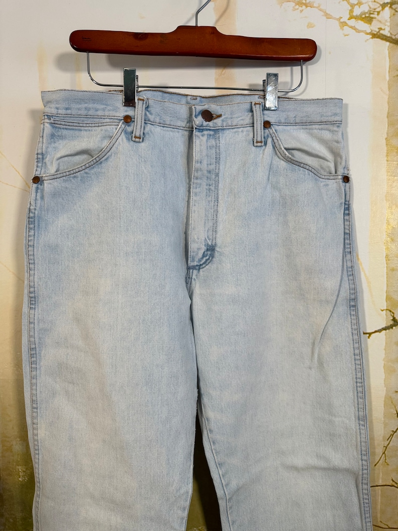 May include: Light blue denim jeans with a classic five-pocket style. The jeans have a straight leg and a high waist.