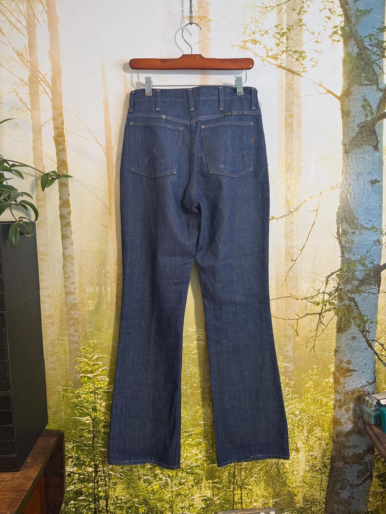 May include: A pair of dark blue denim jeans with a high waist and a wide leg. The jeans have a classic straight leg style and are made of a soft, comfortable denim.