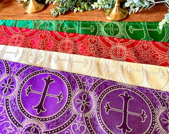 May include: Four altar cloths in different colors, including purple, white, red, and green. Each cloth features a repeating pattern of gold crosses and circles.