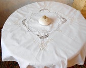 A vintage white cotton tablecloth. Madeira embroidery and crocheted crochet. The antique tablecloth is a gift from the mother.