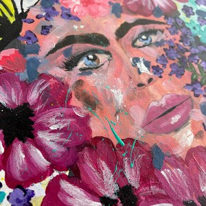 Pode incluir: Pintura abstrata com um rosto parcialmente obscurecido por flores vibrantes. A obra de arte utiliza uma paleta de rosas, roxos e azuis, com pinceladas e respingos de tinta vis&iacute;veis. Os olhos do sujeito s&atilde;o um ponto focal, rodeados por elementos florais.