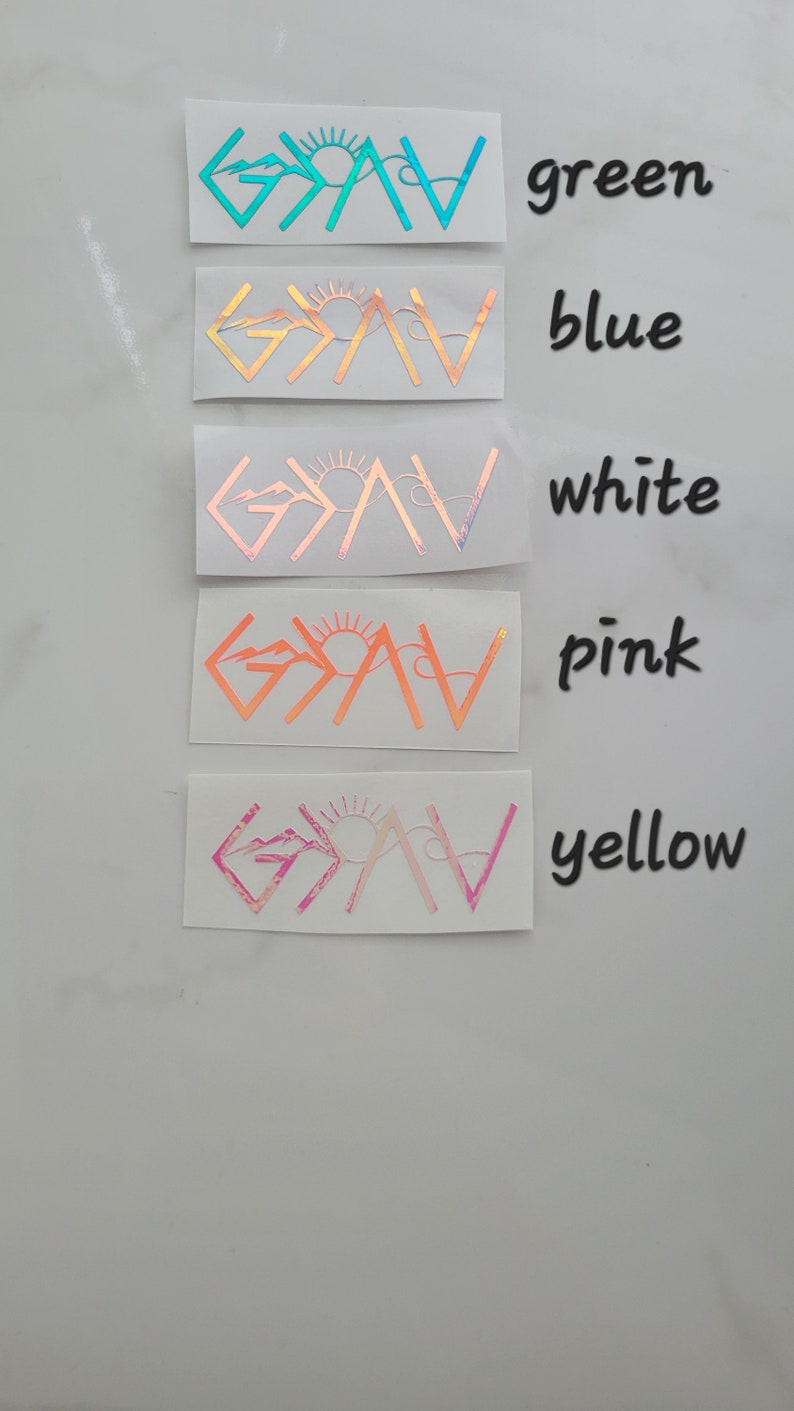May include: A collection of five vinyl stickers in various colors: green, blue, white, pink, and yellow. Each sticker features the word "GAV" with a mountain and sun design. The stickers are displayed on a white surface.