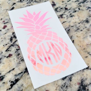 May include: Pink pineapple decal with a monogram in the center. The monogram is the letters "MKD".