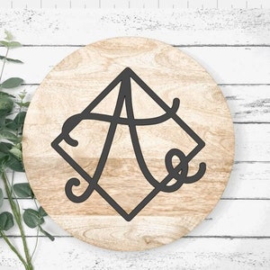 May include: A round wooden sign with a black diamond shape and the letter "A" in a cursive font inside the diamond.
