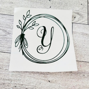 May include: A green vinyl decal with a wreath design and the letter Y in the center.