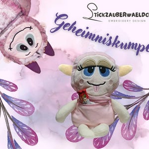 May include: A pink plush toy with a zippered pocket and a cute monster face. The toy is called "Geheimniskrumpel" and is an embroidery design by "Tickzauberwaeldchen".