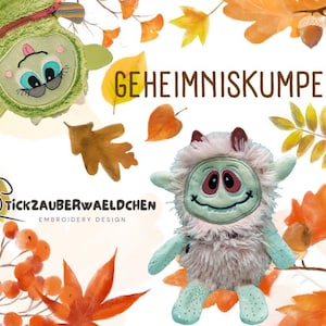 May include: Two plush toys with embroidered faces and autumn leaves. The green toy has a zipper and the white toy has a fluffy texture. The text "GEHEIMNISKUMPEL" is in the background.