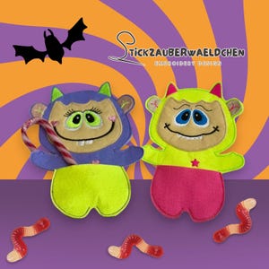 May include: Two felt monster pouches with smiling faces, one holding a candy cane. The monsters are purple and green, with pink and yellow accents. The background is a swirl of orange and purple, with a bat silhouette.