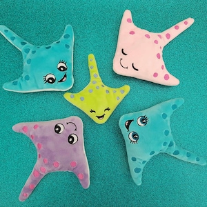May include: Five plush stingray toys in different colors. The stingrays are blue, pink, purple, green, and turquoise. Each stingray has a smiling face with eyes and a mouth.