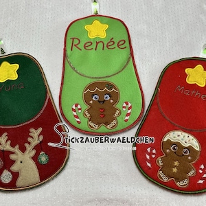 Könnte beinhalten: Drei rote und grüne Weihnachtsstrumpf-Ornamente mit gestickten Lebkuchenmännern und Namen. Die Namen sind "Yuna", "Renee" und "Matheo".