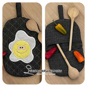 Può includere: Un sottopentola imbottito grigio con un design a uovo fritto sorridente. Il sottopentola ha un anello per appenderlo e può essere utilizzato per riporre cucchiai di legno.
