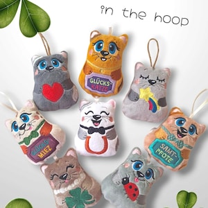 以下が含まれることがあります： 刺繍のディテールが施された、ぬいぐるみ製の猫のオーナメントが8つ。それぞれの猫は、「Glücks Katze」、「Glücks Miez」、「Samt Pfote」など、異なるデザインとメッセージを持っています。