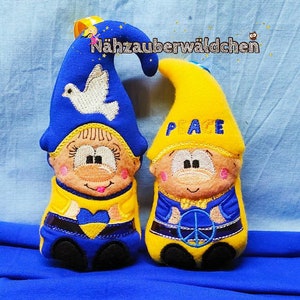 May include: Two plush gnomes with yellow and blue clothing. The gnome on the left has a blue hat with a white dove embroidered on it. The gnome on the right has a yellow hat with the word "PEACE" embroidered on it. Both gnomes have a peace sign embroidered on their clothing.